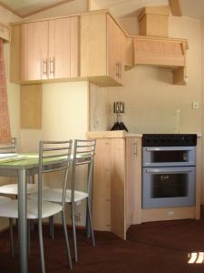 a kitchen with a table and chairs and an oven at Camping Valle Niza Playa in Benajarafe