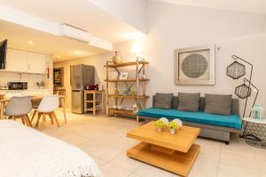 a living room with a blue couch and a kitchen at Cabanas Green Apartment Ria Formosa in Cabanas de Tavira