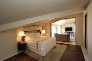 a bedroom with a large white bed and a living room at Kemer Country Hotel İstanbul in Istanbul