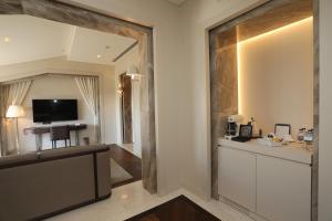 a living room with a television and a mirror at Kemer Country Hotel İstanbul in Istanbul