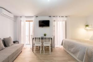 um quarto com uma cama, uma mesa e um sofá em Sagasta Apartamento en pleno centro de Sevilla em Sevilha