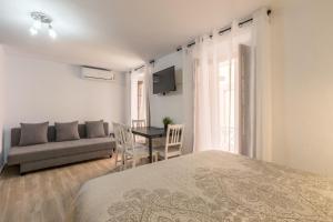 - une chambre avec un lit, un canapé et une table dans l'établissement Sagasta Apartamento en pleno centro de Sevilla, à Séville