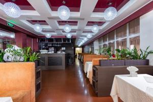 une salle à manger avec des tables, des chaises et des lumières dans l'établissement Terra Nova Sport&Spa Hotel, à Hatne