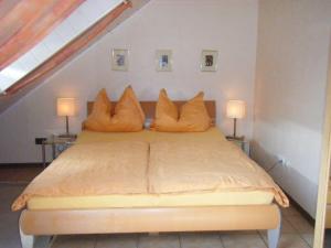 a bedroom with a bed with orange pillows on it at Ferienwohnung M. Lemmermeyer in Neumagen-Dhron