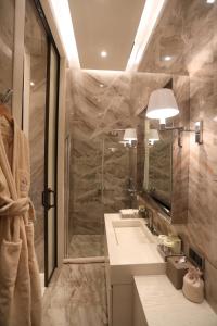 a bathroom with a sink and a shower and a mirror at Kemer Country Hotel İstanbul in Istanbul