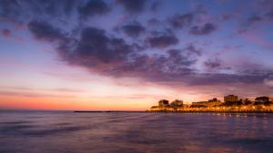 vista para uma praia ao pôr-do-sol com o oceano em Casa Gaddi em Grado
