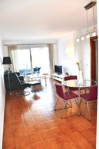 - un salon avec une table et des chaises dans l'établissement Meerblick Apartment Sabina, à Cala Millor