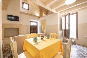una sala da pranzo con tavolo e sedie gialli di Conte Luxury Apartment by Salento Affitti a Racale