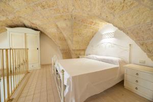 una camera con letto e parete in pietra di Conte Luxury Apartment by Salento Affitti a Racale