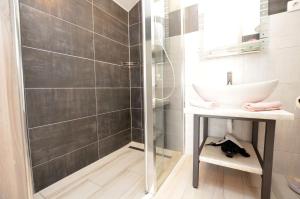 uma casa de banho com um lavatório e um chuveiro em Apartments Viktoria em Lovran