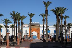 a building with palm trees in front of it at Sultana larache in Larache