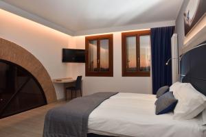 a hotel room with a bed and a desk and windows at Residence Al Barcon in Sarcedo