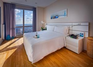 una camera da letto con un grande letto bianco con una grande finestra di Fraser Place Anthill Istanbul a Istanbul