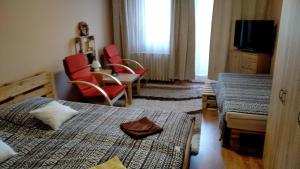 a hotel room with two beds and a table and chairs at Gesztenyés Apartman in Miskolc