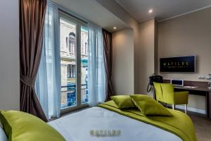 ナポリにあるHotel Matilde - Lifestyle Hotelのベッドと机と窓のある寝室