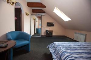 ザポリージャにあるМини-отель Voyageのベッドルーム1室(ベッド1台、椅子、天窓付)