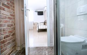 a bathroom with a toilet and a brick wall at Villa Matejuska Heritage in Split