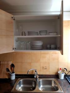 un fregadero en una cocina con platos en un estante en Apartamento Welcome, en Benidorm