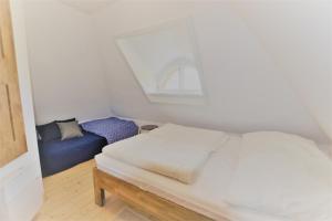 a bedroom with a white bed and a blue couch at Haus am Hügel in Groß Zicker