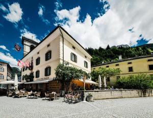 a building with tables and chairs in a courtyard at Hotel Biobistro Semadeni in Poschiavo