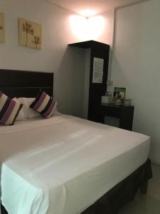 - une chambre avec un grand lit blanc et 2 oreillers dans l'établissement The Blanket Hotel Restaurant & Coffee, à Ilagan