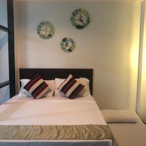 1 dormitorio con 1 cama con placas en la pared en The Blanket Hotel Restaurant & Coffee, en Ilagan