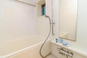 um chuveiro na casa de banho com um espelho em Oakwood Apartments Minami Azabu em Tóquio