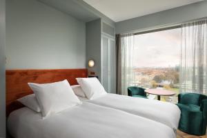 um quarto de hotel com uma cama e uma grande janela em Olympic Hotel em Amsterdã