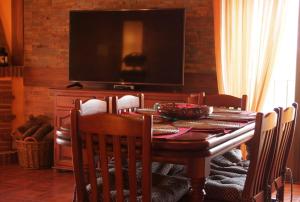 uma sala de jantar com uma mesa com cadeiras e uma televisão em La Casa de la Abuela Mari em Trescasas