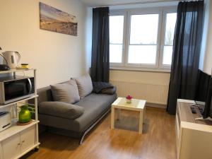 a living room with a couch and a table at Fewo und Meer WHV in Wilhelmshaven