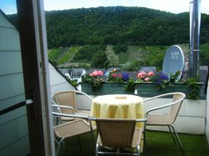 un tavolo con sedie su un balcone fiorito di Ferienwohnung M. Lemmermeyer a Neumagen-Dhron