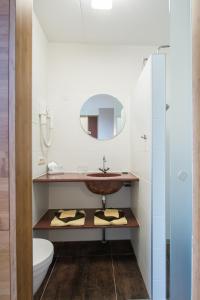 een badkamer met een wastafel, een toilet en een spiegel bij Duinhotel Zomerlust in Zoutelande