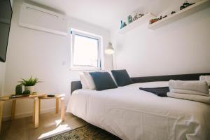 1 dormitorio con cama blanca y ventana en Top Floor Beach Apartment by Silver Prop, en Nazaré