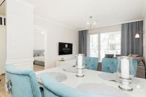 コウォブジェクにあるJantar Apartamenty - Family Vacation Polankiのダイニングルーム(白いテーブル、青い椅子付)