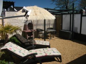 een patio met 2 stoelen en een parasol bij Studio Callanya in Callantsoog