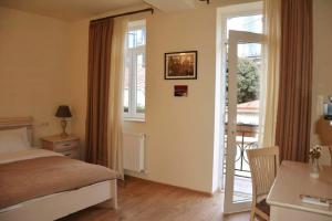 a bedroom with a bed and a sliding glass door at Le Caucase in Tbilisi City