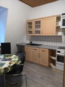 cocina con armarios de madera, mesa, mesa y mesa en Zimmer, en Nordhausen