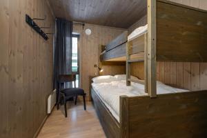 a bedroom with two bunk beds and a chair at Varden Fjellandsby Kvitfjell in Kvitfjell