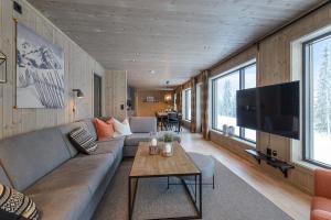 sala de estar con sofá y TV en Varden Fjellandsby Kvitfjell, en Kvitfjell