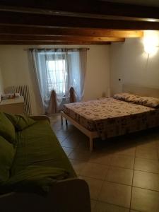 sypialnia z łóżkiem, kanapą i oknem w obiekcie Appartamento" Le Bourg 61" VDA CIR 0208 w Aoście