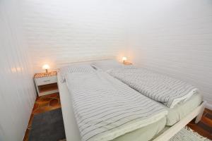 a large bed in a room with two lamps on it at Unterkunft Gotthard in Westerdeichstrich