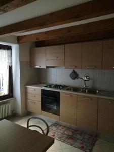 uma cozinha com armários de madeira e um forno com placa de fogão em Appartamento" Le Bourg 61" VDA CIR 0208 em Aosta