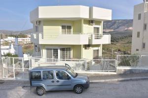 a small blue car parked in front of a building at Double M near Athens Airport in Markopoulo