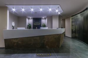 ナポリにあるHotel Matilde - Lifestyle Hotelのフロントカウンターと照明付きのホテルロビー