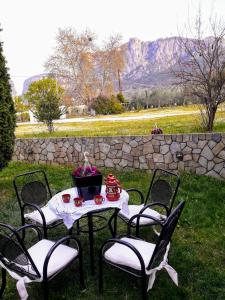 una mesa y sillas con una mesa y flores. en Meteora best view villa, en Kalambaka