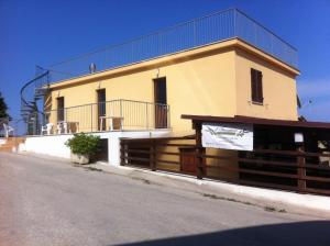 un edificio giallo con una recinzione di fronte di Il Frantoio a Lapedona