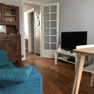 a living room with a couch and a television at Maison Bernadette - Premier Etage in Vitry-sur-Seine