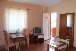 salon z telewizorem, stołem i krzesłami w obiekcie Apartments Isabela w Bašce