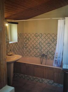 a bathroom with a bath tub and a sink at Gîtes de la roblinière in Landevieille