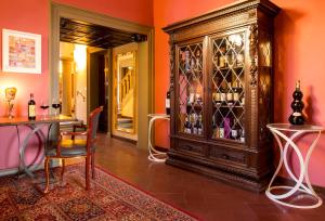 Art Hotel Villa Agape في فلورنسا: غرفة مع خزانة خشبية كبيرة مليئة بأكواب النبيذ